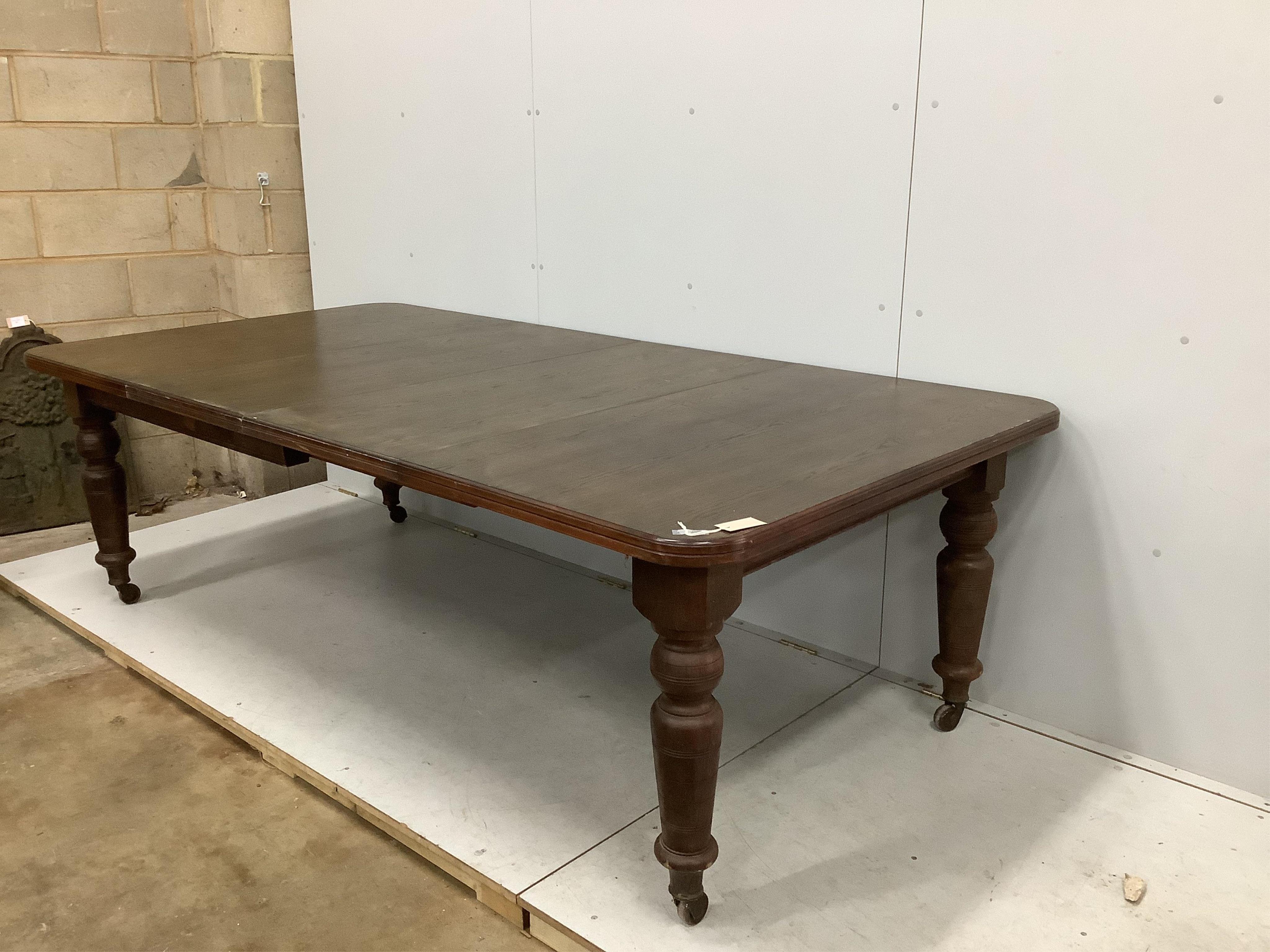 A late Victorian oak extending dining table, width 240cm extended, two spare leaves, depth 120cm, height 74cm. Condition - fair